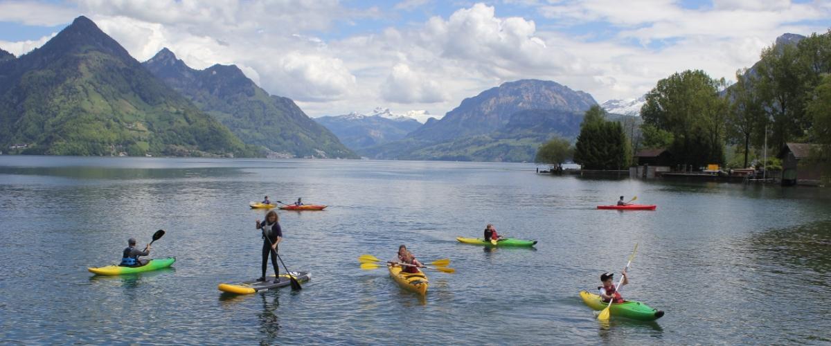 Gruppe von Kajakfahrern und Stand-Up Paddlerin auf dem See