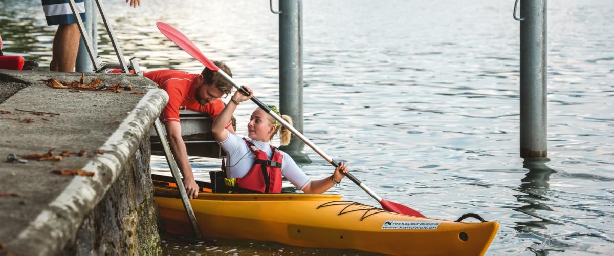 Kanuwelt-Guide hilft Gast beim Einsteigen ins Seekajak